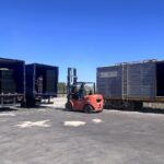 Operación de transbordo de carga desde camión a tren mediante autoelevador en esquema logístico multimodal.